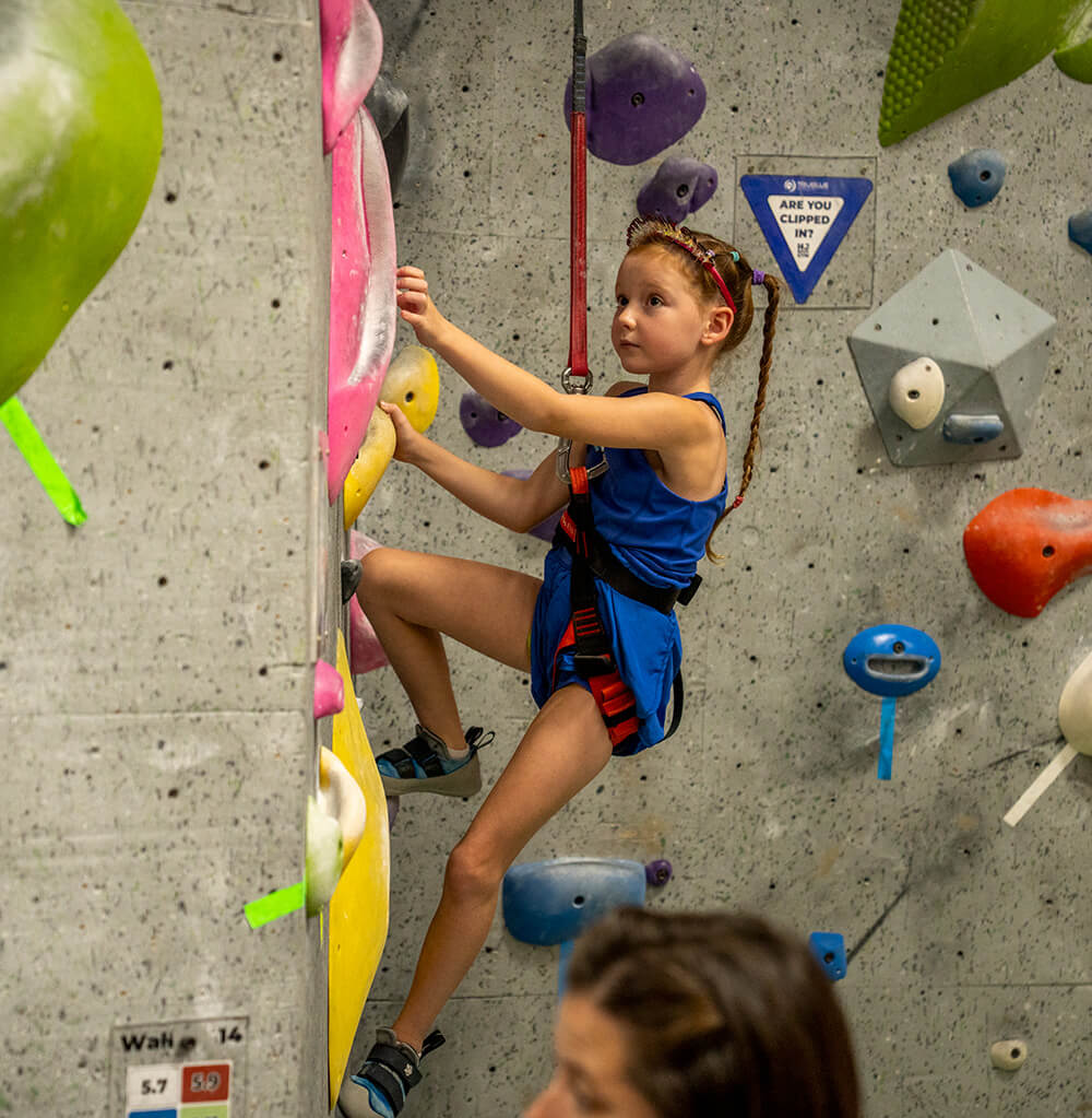 Young girl rock climbing at NJ Rock Gym in New Jersey.